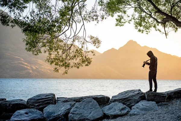 Młody Podróżnik Fotograf Biorąc Zdjęcie Jeziora Wakatipu Podczas Zachodu Słońca — Zdjęcie stockowe