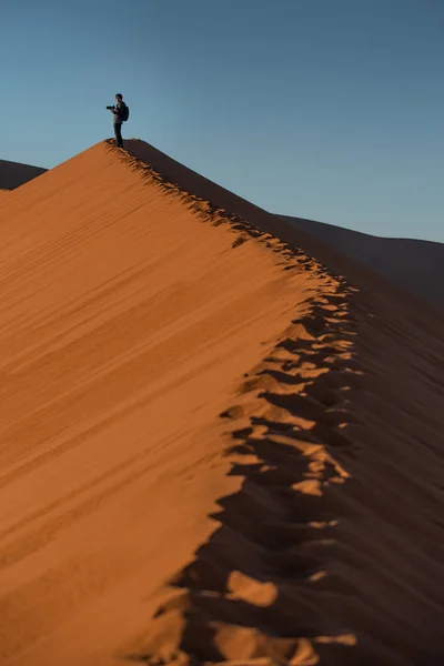Молодой Азиат Путешественник Фотограф Стоящий Вершине Песчаной Дюны Фотографирующий Восход — стоковое фото