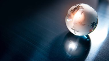 Dünya küre kristal cam mavi parlak masaya yansıtır. Küresel iş ve ekonomi. Çevre koruma veya ekoloji kavramı