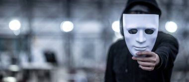 Gizemli kapüşonlu adam beyaz maske holding