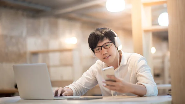 Asiatiska man lyssna på musik på mobilappen — Stockfoto