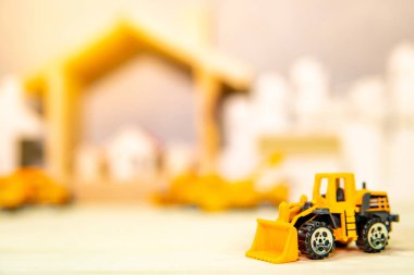Ahşap masa üzerinde minyatür sarı traktör modeli