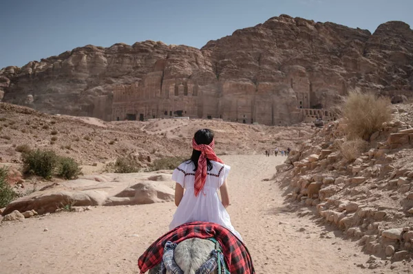 Asiatisk kvinna turist ridning åsna i Petra, Jordanien — Stockfoto