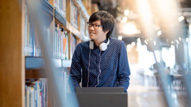 Üniversite kütüphanesinde Asyalı adam üniversite öğrencisi