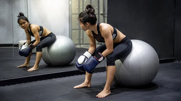 Asiática chica boxeador sentado en ejercicio pelota en gimnasio — Foto de Stock