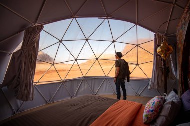 Tourist man in dome tent at Wadi Rum, Jordan clipart