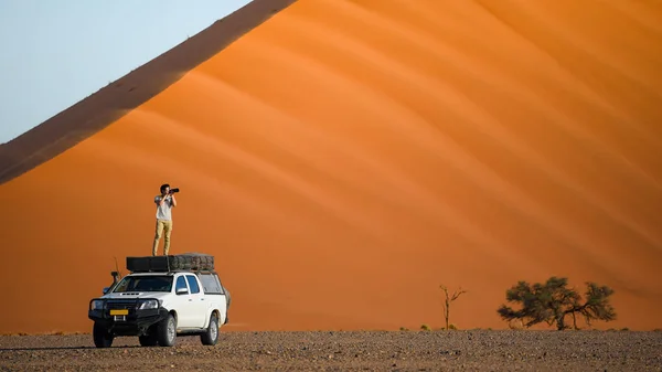 Asian traveler on camper car near sand dune — Stock Photo, Image