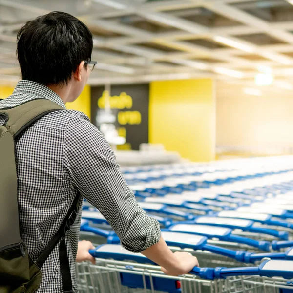 Asiático homem puxando carrinho de compras no supermercado — Fotografia de Stock