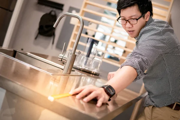 Hombre asiático usando cinta métrica en el mostrador de cocina —  Fotos de Stock