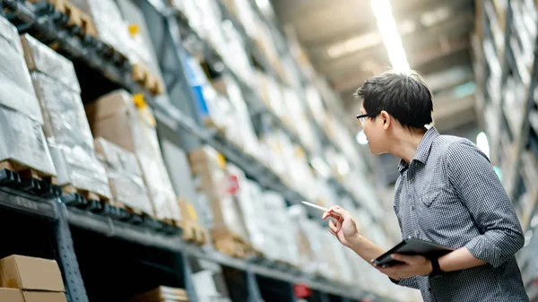 Hombre asiático haciendo inventario en tableta en el almacén — Foto de Stock