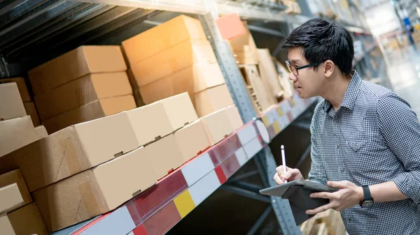 Hombre asiático haciendo inventario en tableta en el almacén — Foto de Stock