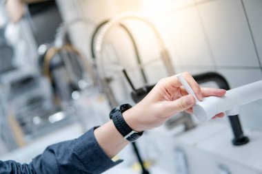 Mobilya mağazasında su musluğu seçimi erkek el