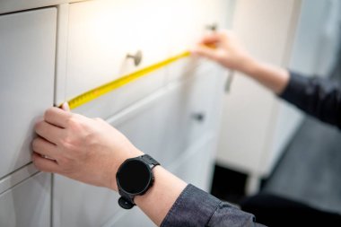 Dolap çekmecesinde bant ölçüsü kullanan erkek el