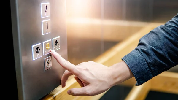 Mano maschile premendo il pulsante di emergenza in ascensore — Foto Stock