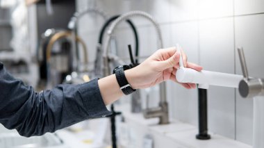 Mobilya mağazasında su musluğu seçimi erkek el