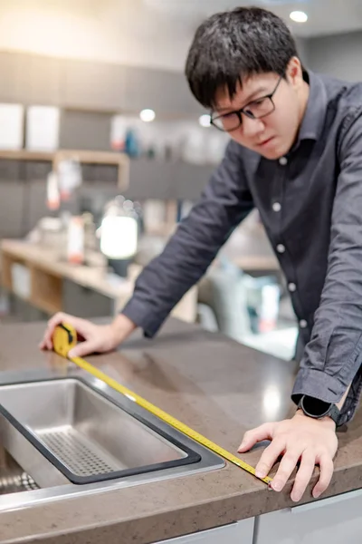 Asya adam kullanarak bant ölçmek üzerinde mutfak sayaç