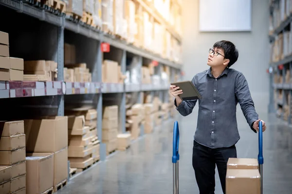 Hombre asiático haciendo inventario en tableta en el almacén —  Fotos de Stock