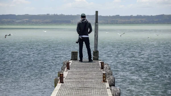 Fotograf în picioare pe jetty lângă lac — Fotografie, imagine de stoc