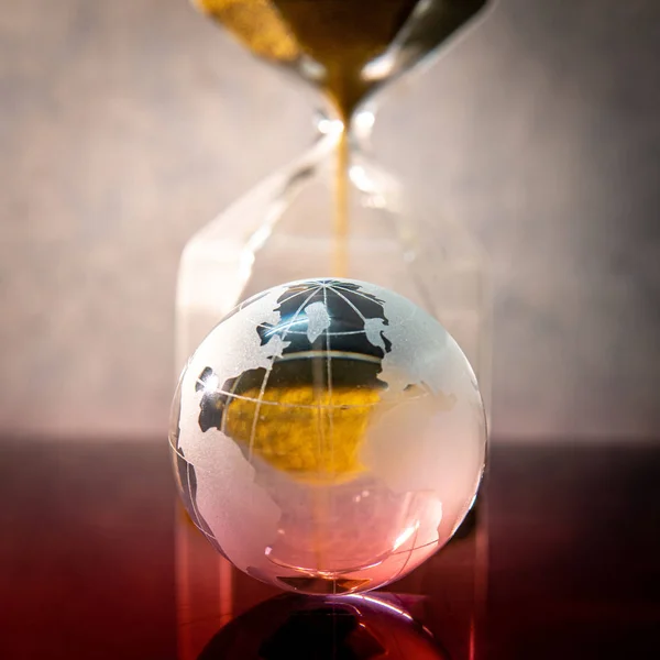 Hourglass and world globe crystal on the table