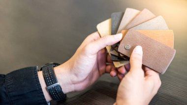 Erkek mimar elinde ahşap bir kumaş parçası tutuyor.