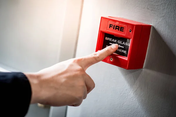 Male hand pointing at red fire alarm switch — Stock Photo, Image