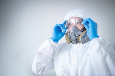 Bilimadamı ya da Virolojist adam biyolojik tehlike kimyasalı koruyucu kıyafet, gözlük ve maske takıyor. Koronavirüs (COVID-19) enfeksiyonunu önlemek için PPE ve kauçuk eldiven giyen erkek doktor veya sağlık görevlisi.