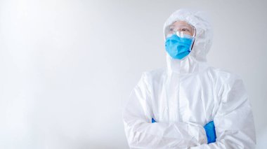 Hastane kliniğinde kollarını kavuşturup poz veren doktor ya da doktor. Koronavirüsü önlemek için PPE giysisi, maskesi ve gözlüğü olan bir sağlık çalışanı (COVID-19).