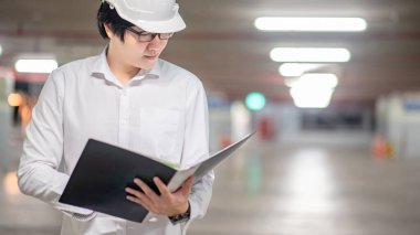 Asyalı inşaat mühendisi ya da koruma kaskı takan inşaat işçisi. İnşaat alanında çalışan erkek mimar. İnşaat ve mimari kavramı