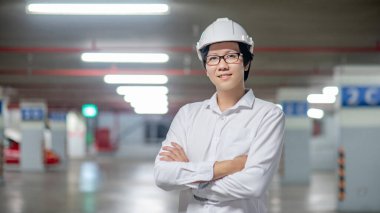 Asyalı inşaat mühendisi ya da koruma kaskı takan inşaat işçisi. İnşaat alanında çalışan erkek mimar. İnşaat ve mimari kavramı