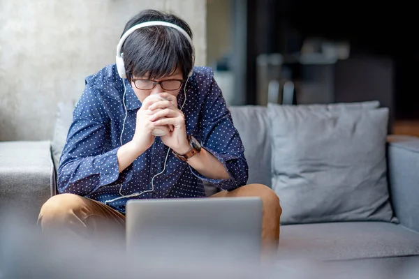 Hombre Negocios Asiático Con Auriculares Gafas Sentado Cómodo Sofá Beber — Foto de Stock