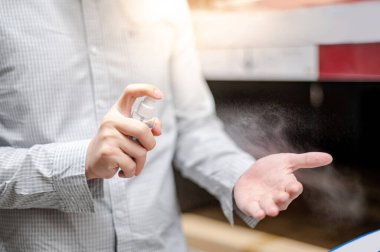 Dezenfektan spreyiyle elini temizliyor. Erkek eller halka açık alanda Coronavirus (COVID-19) enfeksiyonunu önlemek için alkol sıkarlar. Antibakteriyel ürünle sağlık hizmeti.