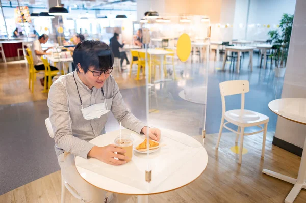 Asiatische Mann Sitzt Tischabschirmung Trennwand Beim Essen Croissant Und Kaffee — Stockfoto