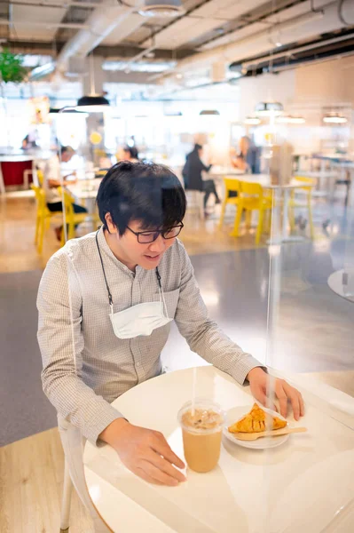 Asiatische Mann Sitzt Tischabschirmung Trennwand Beim Essen Croissant Und Kaffee — Stockfoto