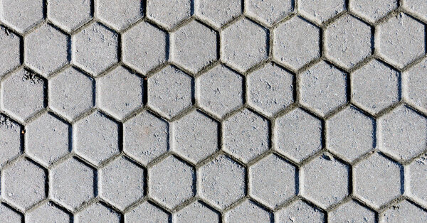 Gray background image of hexagonal clay tiles, walking path in the park.