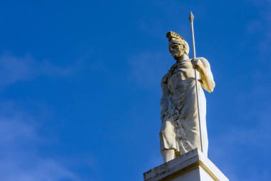 Heykel ve gökyüzüne karşı mızraklı antik Yunan savaşçısı.