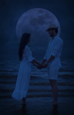 Ayakta ve birlikte sahilde fantezi gece gökyüzü, ay ve deniz, tatil balayı ve düğün kavramı üzerinde elele romantik sevgi dolu çift