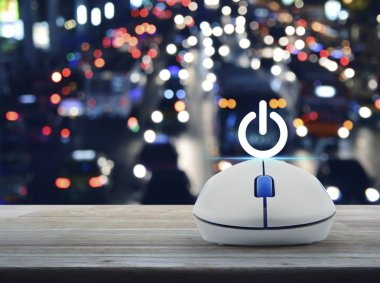 Güç düğmesi kablosuz bilgisayar fare ile üzerinde ahşap masa üzerinde renkli gece ışık şehir araçları ile bulanık, iş kavramı başlatmak