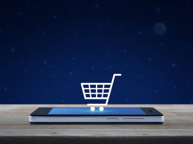 Ahşap masa fantezi gece gökyüzü ve ay, alışveriş online kavramı üzerinde modern akıllı telefonun ekranında alışveriş sepeti simgesine