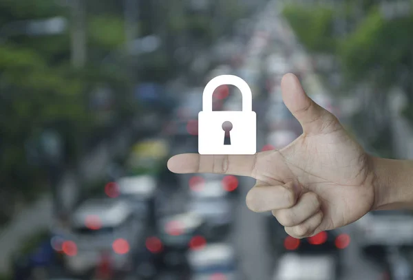 Key icon on finger over blur of rush hour with cars and road, Business security concept