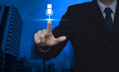 Mikrofon düz simgesi basarak modern ofis şehir kule ve gökdelen, iletişim iş kavramı üzerinde işadamı