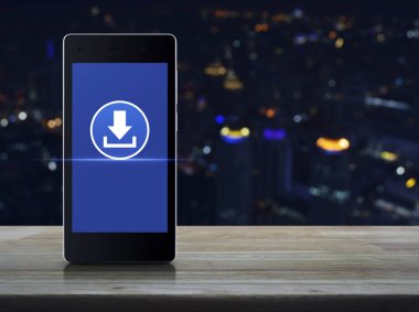 Modern akıllı cep telefonu ekran üzerinde ahşap masa üstünde kutsal kişilerin resmi bulanık renkli gece ışık şehir Kulesi, işyeri internet online kavramı üzerinde download