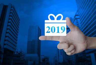 Hediye kutusu mutlu yeni yıl 2019 düz kutsal kişilerin resmi üstünde parmak modern ofis şehir kule ve gökdelen, iş online kavramı alışveriş üzerinde