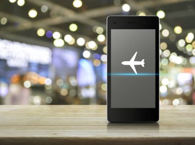 Uçak düz ahşap masa üzerinde modern akıllı cep telefonu ekran simgesine bulanıklık ışık ve gölge, Alışveriş Merkezi, iş uçak ulaşım online kavramı
