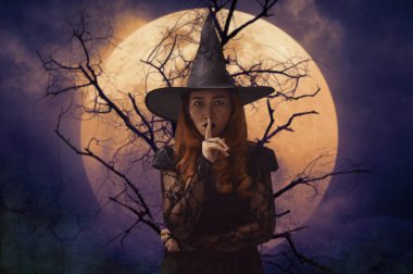 Halloween cadı gösteren sessizlik ölü ağaçlar, dolunay ve ürkütücü bulutlu gökyüzü, Cadılar Bayramı gizem kavramı üzerinde duran dudakları parmak ile yazı