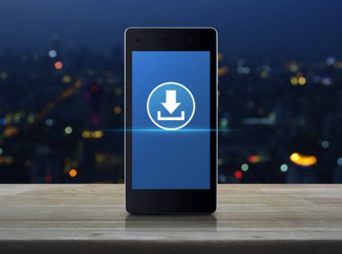Download düz ahşap masa üzerinde modern akıllı cep telefonu ekran simgesine bulanıklık renkli gece ışık şehir kule ve gökdelen, teknoloji internet online kavramı