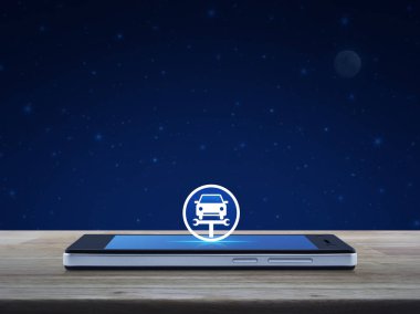Hizmet düzeltme araba anahtarı aracı simgesini ahşap masa üzerinde fantezi gece gökyüzü ve ay ekranda modern akıllı cep telefonu ile iş tamir araba online kavramı