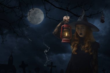 Ölü ağaçlar, yarasa, dolunay ve bulutlu gökyüzü, Cadılar Bayramı gizem kavramı üzerinde eski lamba ayakta tutan Halloween cadı