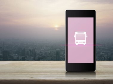 Otobüs düz ahşap masa üzerinde şehir Kulesi, gün batımı, vintage tarzı modern akıllı cep telefonu ekran simgesine, iş ulaşım hizmet online kavramı