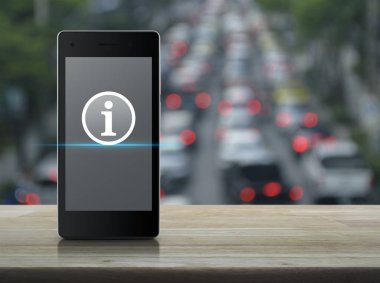 Ahşap masa üzerinde modern akıllı cep telefonu ekranda bilgi işareti düz simgesini bulanıklık bitirim otomobil ve yol City, online iletişim iş kavramı ile
