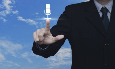 İş adamı, beyaz bulutlu mavi gökyüzü üzerine mikrofon resmi basıyor, iş iletişimi kavramı.